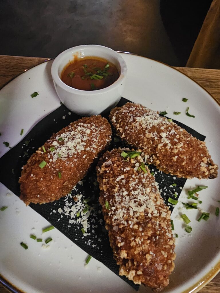 Crispy parmesan-crusted arancini with marinara dipping sauce at Camp West