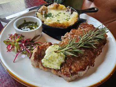 Camp West ribeye with herb butter and rosemary, a cast iron skillet potato and chimichurri